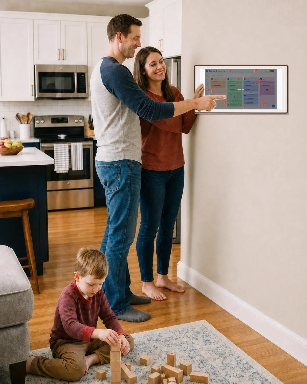 Parents use a 27-inch walnut-frame digital family calendar while their child plays with wooden blocks in the kitchen.