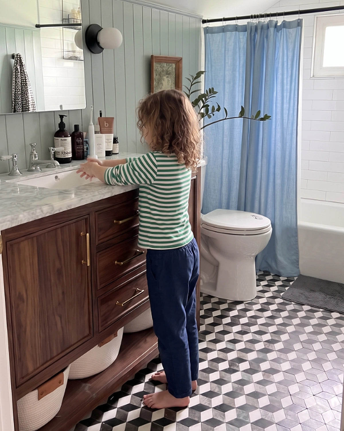 Young child washing their hands at a bathroom sink